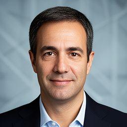 Professional headshot of a Melbourne accounting director in a dark blazer against a subtle geometric background